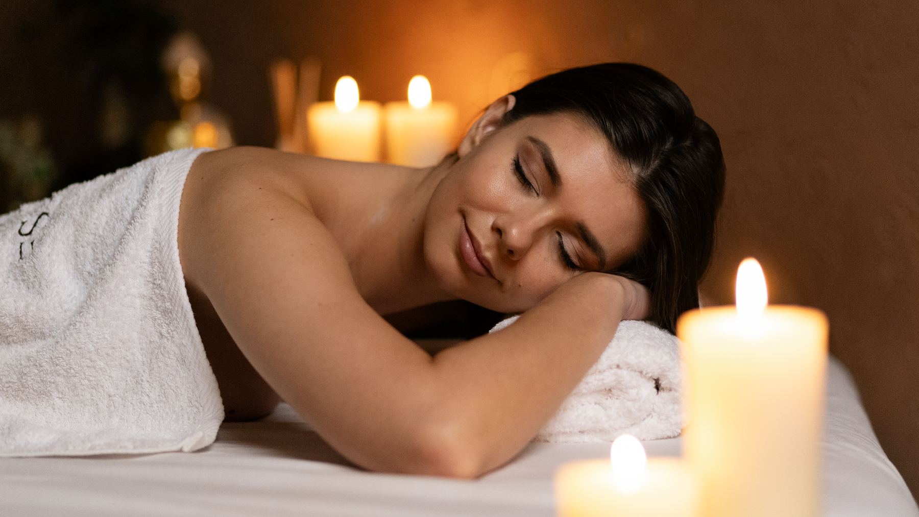 Žena odpočívá v klidu při svíčkách během rituálu klidu v salonu ESCAPE